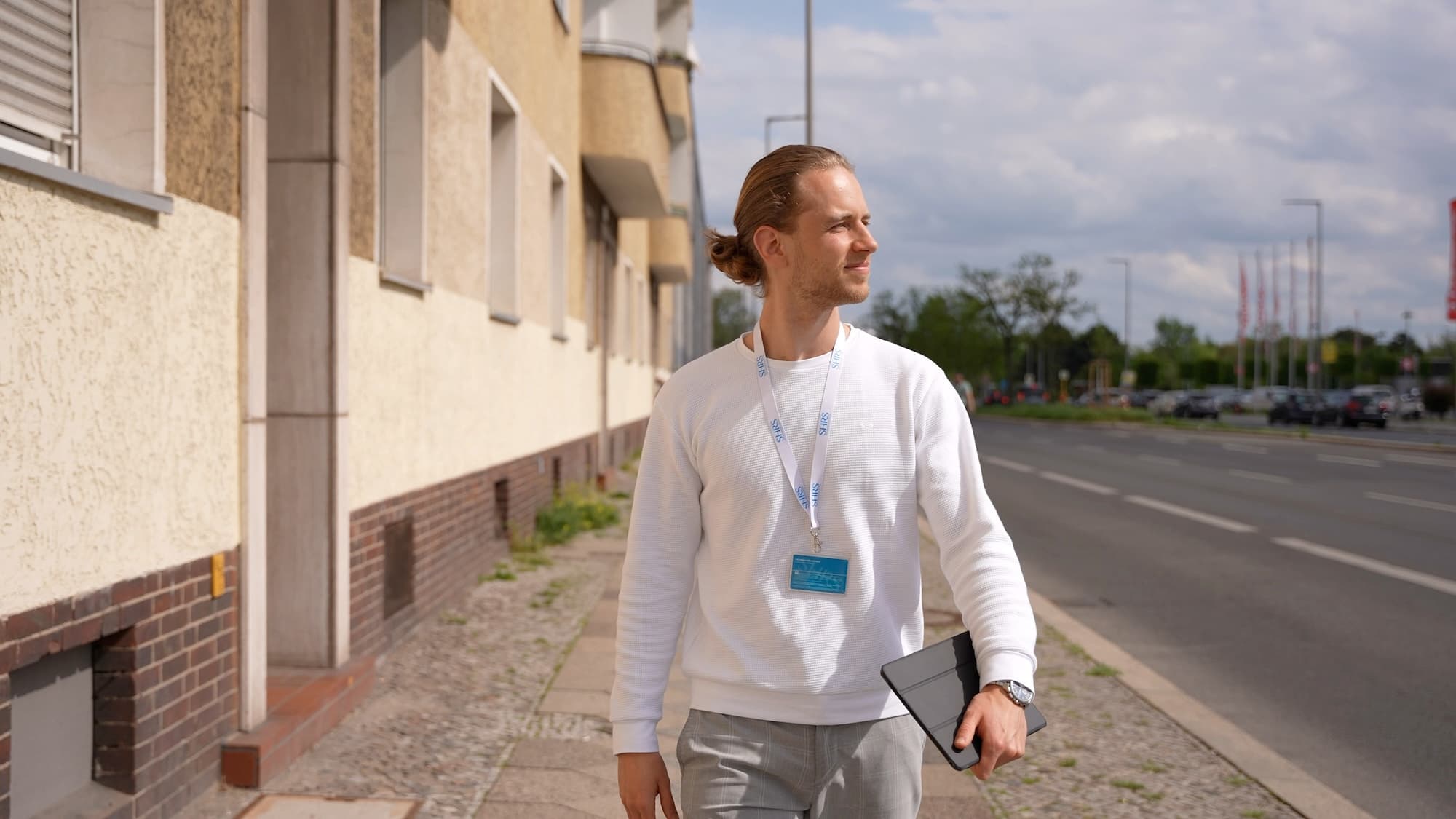 Jan Bendel unterwegs im Gebiet, mit Ausweis und Tablet auf dem Gehweg
